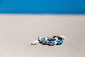 Fototapeta na wymiar copy space beautiful decoration from seashells for girls lies on white sand