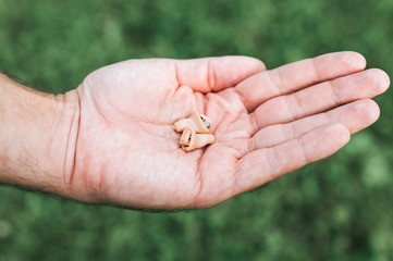 small intra channel hearing aid device in a man's hand