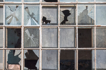 Old window frame of industrial building with broken glass