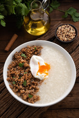 congee with pork and egg on wood food background 