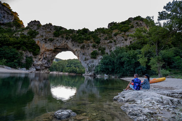 couple on the beach by the river in the Ardeche France Pont d Arc, Ardeche France,view of Narural...