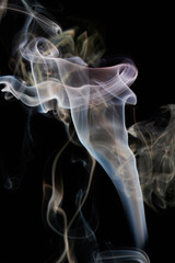 Fototapeta premium Yellow smoke swirls on black background