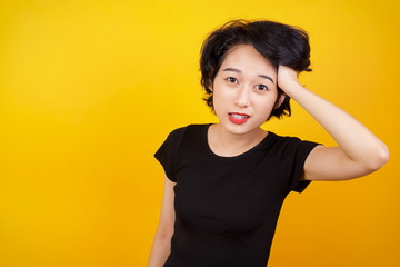 Worried and anxious woman can not remember anything. Portrait of confused cute girl wearing casual clothes, holding hand on hair and frowning, panicking, losing memory over gray wall