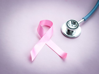 Breast cancer awareness pink ribbon with doctor stethoscope on pink background, october symbol, healthcare and medicine concept