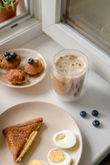 Breakfast with granola, eggs, coffee and cakes