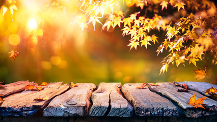 Wooden Table With Red And Yellow Leaves At Sunset - Autumn Background

