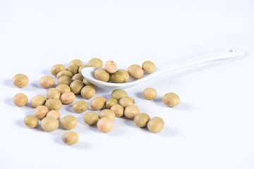 Yellow-green Taiwanese organic non-GMO soybeans, soy beans in a container isolated on white backgorund, close up, clipping path.