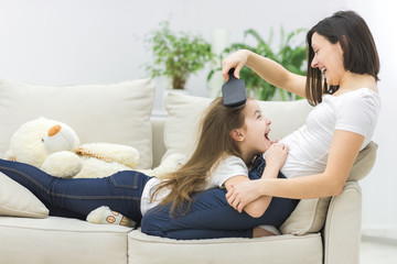 Obraz premium Photo of woman combing hair of her child.