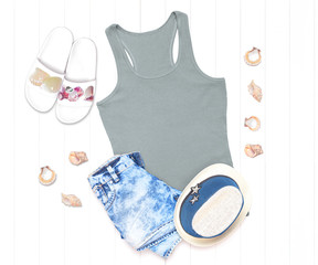 Gray tank top with shells, hat and flip flops on a white background