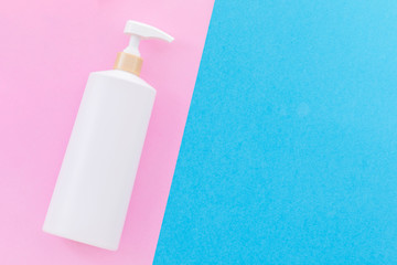 Blank white plastic pump bottle used for shampoo or soap on blue background