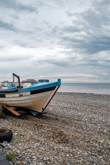 A traditional crab fishing boat on the shingle at Cromer beach after a morning at sea setting crab pots. This is portrait orientation with copy space