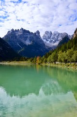 Dolomites mountains(Monte Cristallo) in South Tirol, Italy,emerald colored lake Duerrensee(Landro)in front,reflections on the water surface,autumn landscape,blue sky with clouds background,a sunny day