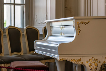 White vintage grand piano in the old living room. vintage interior.