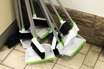 Plastic household brushes, scoops and mops in the hardware store