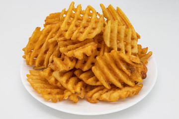 Large Pile of Waffle Fries on a White Plate with a White Background