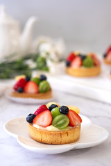 Fresh homemade fruit tart with .grape, strawberries and  blueberries on white background
