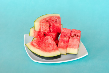 Water melon slices on a plate on blue background