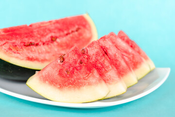 Water melon slices on a plate on blue background