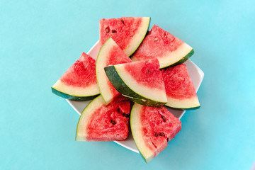 Water melon slices on a plate on blue background