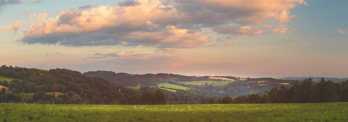 beautiful sunset landscape with meadows and hills