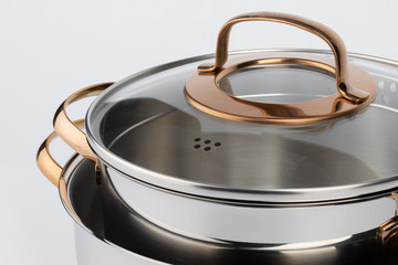 Set of new metal saucepans isolated on white