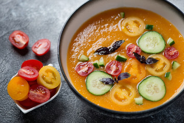 Bowl of golden gazpacho cream-soup made of yellow tomatoes, selective focus, close-up