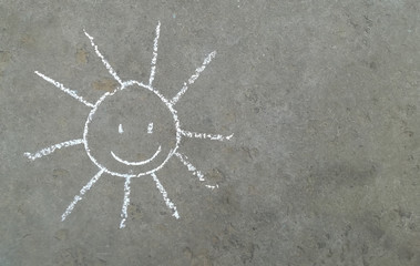 sun with a smile is drawn in chalk on the asphalt. banner with place for your text, copy space....