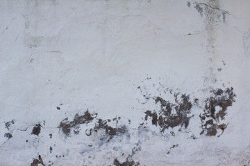wall texture with old white plaster that has cracked and fallen off