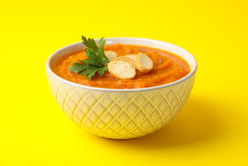 Bowl of pumpkin puree on yellow background