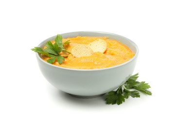 Bowl of pumpkin soup with croutons and parsley isolated on white background