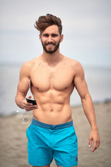 Obraz premium Attractive man walking on the beach; Hot guy concept