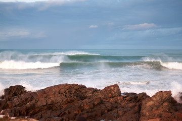 Fototapeta na wymiar Powerful sea waves crushing to the rocks on the shore
