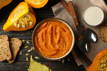 Composition with pumpkin soup on wooden background, top view