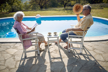 Obraz premium Senior man and woman enjoy on summer holiday near swimming pool.