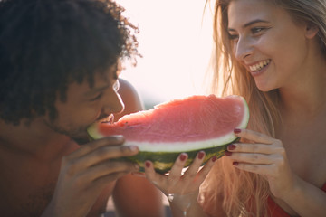 Romantic  couple  enjoy on summer holiday near swimming pool and  eating watermelon.