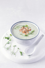 Avocado and spinach cream soup with nuts and microgreens. Diet food concept. Vegetarian and vegan food