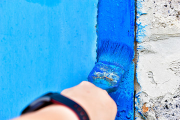 Painting iron surfaces with a blue paint brush