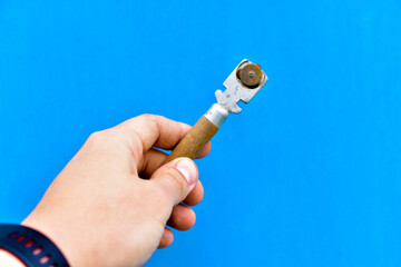 Special glass cutter in hand on a blue background