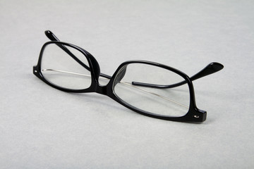 Black rectangular eyeglasses on gray background