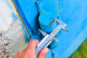 Measurement of iron parts with a caliper on a blue background