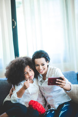 African daughter taking selfie a picture with her mother at home