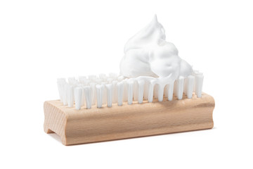 One wooden cleaning washing brush with synthetic nylon, polyester bristles and soap suds bubble or fluff frothed scouring foam on top. Isolated on white background. Cleaning service company concept.
