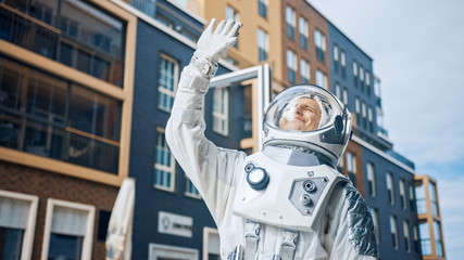 Low Angle Footage of a Confident Handsome Astronaut Looking at the Bright Blue Sky and Covers the...