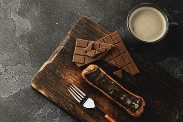 Eclair cake on dark wooden board on black table