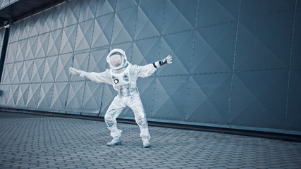 Handsome Man in Spacesuit is Dancing Next to Metal Wall. Astronaut is Happy and Makes Creative...