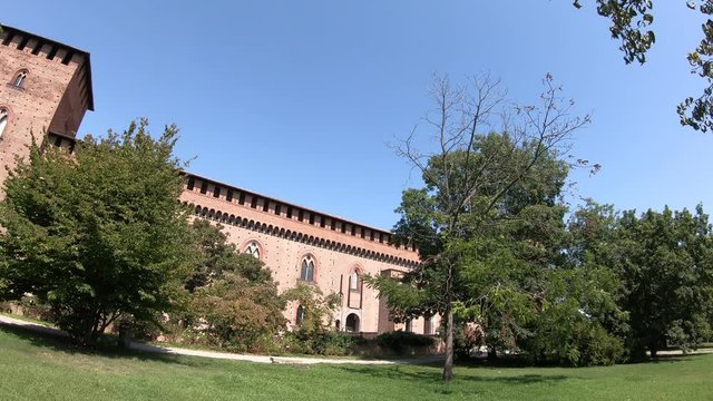 Pavia, Italy - August 13, 2020: 4K Tilt plus Pan shot from a tree branch to the Visconti Castle of Pavia