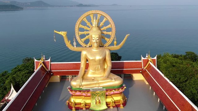 Thailand landmark. Aerial view of golden Buddha statue of the Big Buddha temple with sea on background in Koh Samui