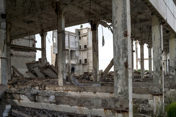 Fototapeta premium Destroyed large concrete building without external walls with a visible frame of piles and beams. Background