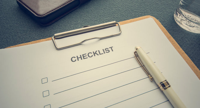 A checklist paper with clipboard on the desk. Image in vintage style.