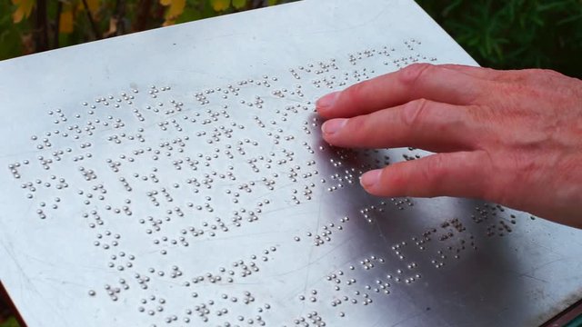 Hand touches the description in Braille. Typhlo pedagogue takes into account the blind and visually impaired people to read, instills in them self-service skills, the ability to navigate in space.